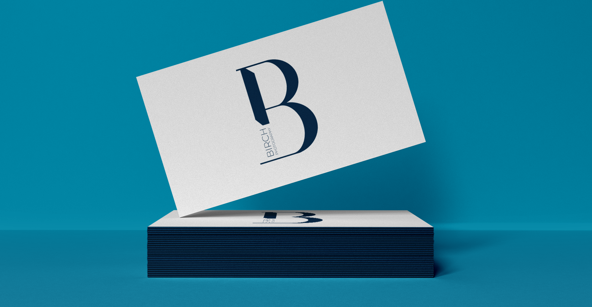 stacked business cards displaying Birch Photography's logo.