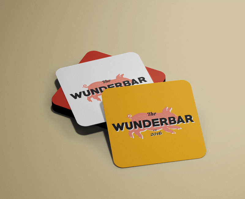 A stack of red, yellow and whiet drinks caosters with the Wunderbar logo on them.